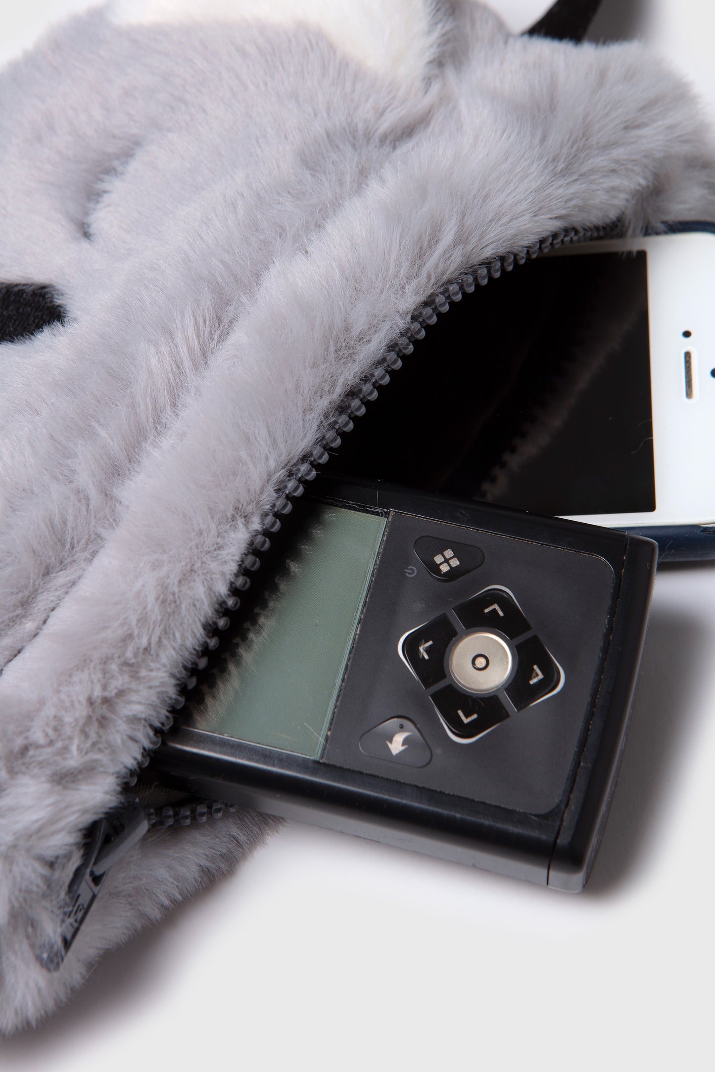 
                  
                    cremallera abierta mostrando bomba de insulina medtronic 780g y teléfonc móvil 
                  
                