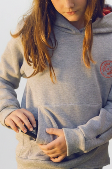 
                  
                    os niña con sudadera gris bordado coral manipulando bomba de insulina, fondo blanco estudio
                  
                